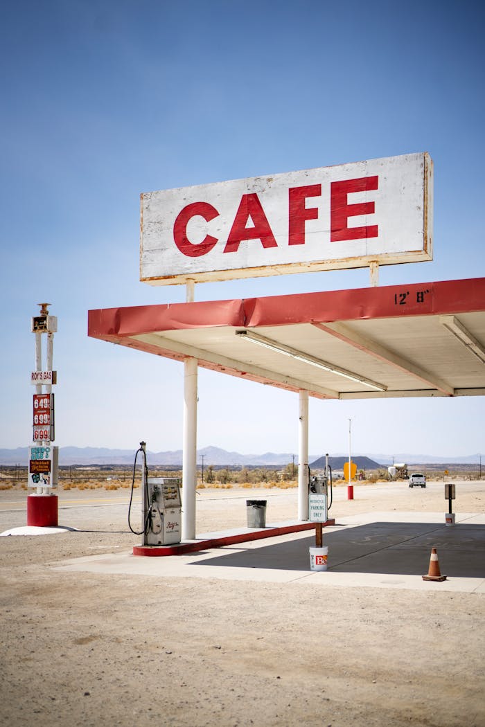about-us-01 Desert gas station with a vintage cafe sign, empty and nostalgic.